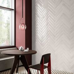 a table and two chairs in a room with red walls, white chevron tiles on the wall