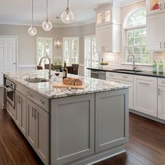 a large kitchen with an island in the middle of it and lots of counter space