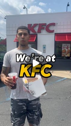 a man standing in front of a kfc holding a drink