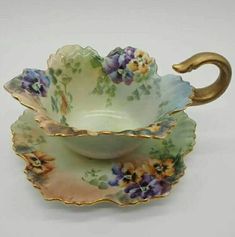 an antique tea cup and saucer decorated with flowers