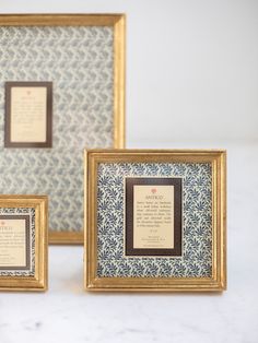 three framed pictures on a white table with blue and gold designs, one has a poem in the middle