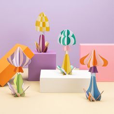 colorful paper sculptures on display against a purple background