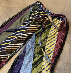 several ties laid out on the floor in a row, all different colors and patterns