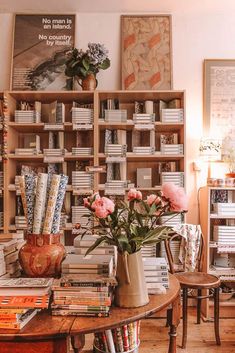 a room filled with lots of books and vases on top of a wooden table