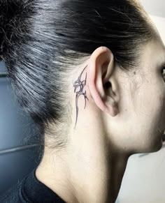 a woman with a tattoo behind her ear