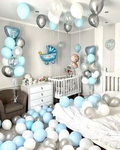 a baby's room with blue and silver balloons