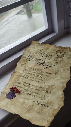 a piece of paper with writing on it sitting in front of a window sill