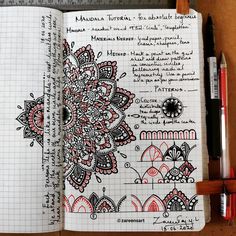 an open notebook with doodles and writing on the pages, next to a red pen