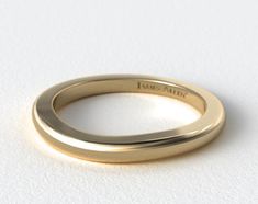 a gold wedding band with the word love also engraved on it's side, in front of a plain white background