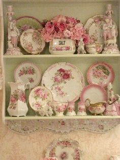 an old china cabinet with pink flowers and plates on it's shelves in a kitchen