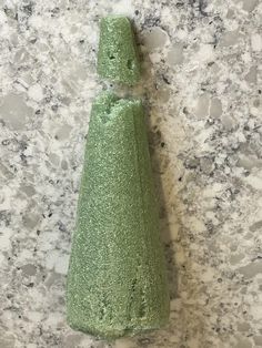 a green vase sitting on top of a marble counter