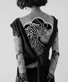 the back of a woman with tattoos on her body