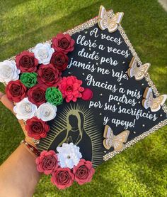 someone holding up a graduation cap with flowers on it in the grass and saying, i love a recess duee