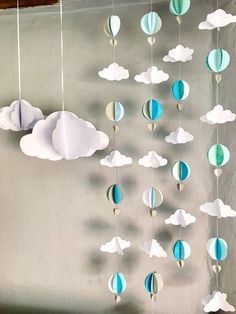 some paper clouds are hanging from the ceiling and there is a sign that says pastel summer blues