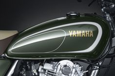 the yamaha motorcycle is green and white with gold lettering