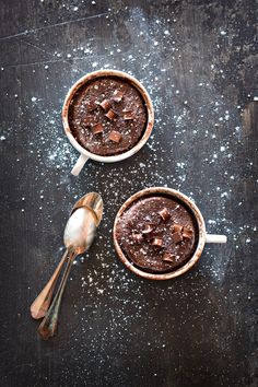 two bowls filled with chocolate pudding on top of a table