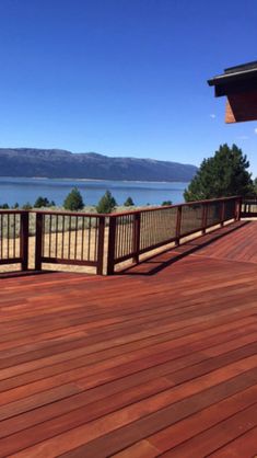 a wooden deck with railings overlooking the water