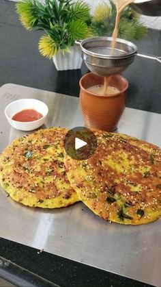 two pancakes sitting on top of a metal pan next to a bowl and saucer