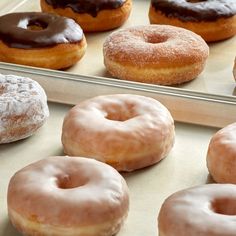 there are many different kinds of doughnuts on the tray