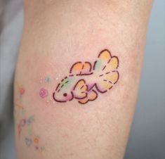 a small fish tattoo on the left side of someone's right arm and leg