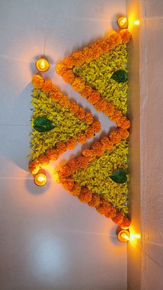 a decorated triangle made out of flowers and lit candles