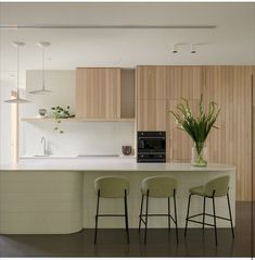 a kitchen with three stools next to an island