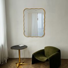 a chair and table in front of a mirror on the wall next to a window