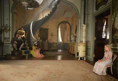 people are sitting on the stairs in an old house