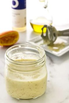 a glass jar filled with liquid sitting on top of a counter next to an orange slice