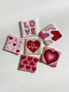 four pieces of felt with hearts and love written on them, all in different colors