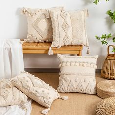 pillows and blankets are arranged on a bench next to a potted plant in a room