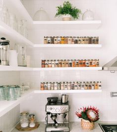 a kitchen with shelves filled with spices and condiments on top of the counter