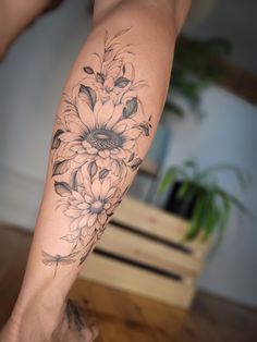 a woman's leg with a flower tattoo on her left arm and the bottom half of her leg