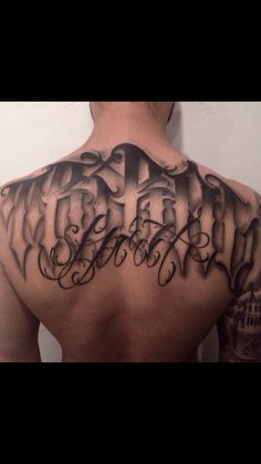 the back of a man's upper half with his name tattooed on it