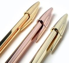 three different types of fountain pens lined up on a white surface with one pen pointed at the other end