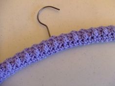 a purple crochet hook on a white surface