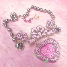 The Opulent necklace ~ inspired by those 80's magic key Clarkes shoes (you know the ones!) with a pink butterfly engraved illustration on iridescent rainbow acrylic ~ comes on a silver pearl chain with lilac crystal heart embellishments and a silver metal finish Main Charm size (inlcuding bow): 6 x 8cm Necklace length : 36cm, Extender 6cm Hand made and hand-illustrated with love in the UK Pink Butterfly Charm Necklace For Party, Pink Butterfly Charm Necklace For Gift, Pink Butterfly Necklace Gift, Pink Butterfly Necklace For Gift, Handmade Pink Harajuku Style Necklace, Harajuku Style Silver Necklace For Gift, Cute Butterfly Necklace For Gift, Cute Butterfly Charm Necklace For Gift, Pink Harajuku Style Jewelry Gift