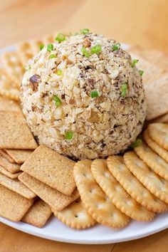 a plate with crackers, crackers and a cheese ball on top of it