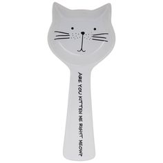 a white cat shaped spoon with black writing on it