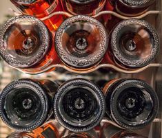 there are many bottles and glasses in the wine rack