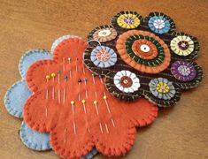 three flower brooches sitting on top of a wooden table