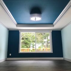 an empty room with blue walls and white trim