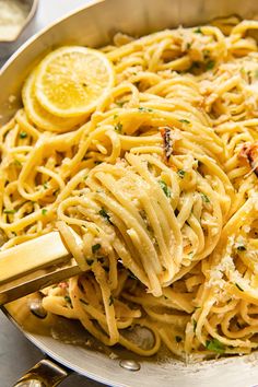 a pan full of pasta with lemons and parmesan cheese