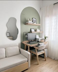 a white couch sitting in front of a computer desk