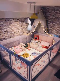 a baby crib in the middle of a room with lights strung from it's ceiling