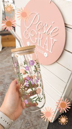 a person holding a mason jar with flowers inside and the words paste gray above it