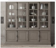 a gray china cabinet with glass doors and dishes