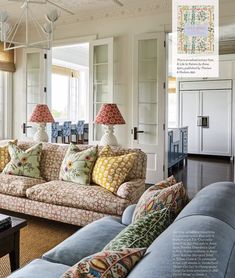 a living room with couches and lamps on the wall in front of windows that look out onto an outdoor deck