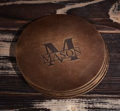 three personalized leather coasters with the word mason on them sitting on a wooden surface