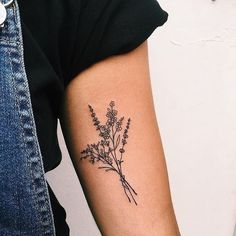 a woman's arm with a flower tattoo on the left side of her arm